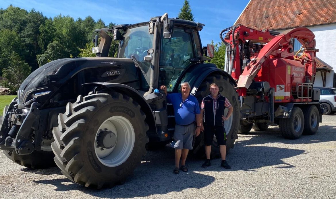 Übergabe-Foto eines Valtras Q305. Zu sehen sind unser Kunde Raith Georg & unser Verkäufer Martin vor dem Valtra-Schlepper.