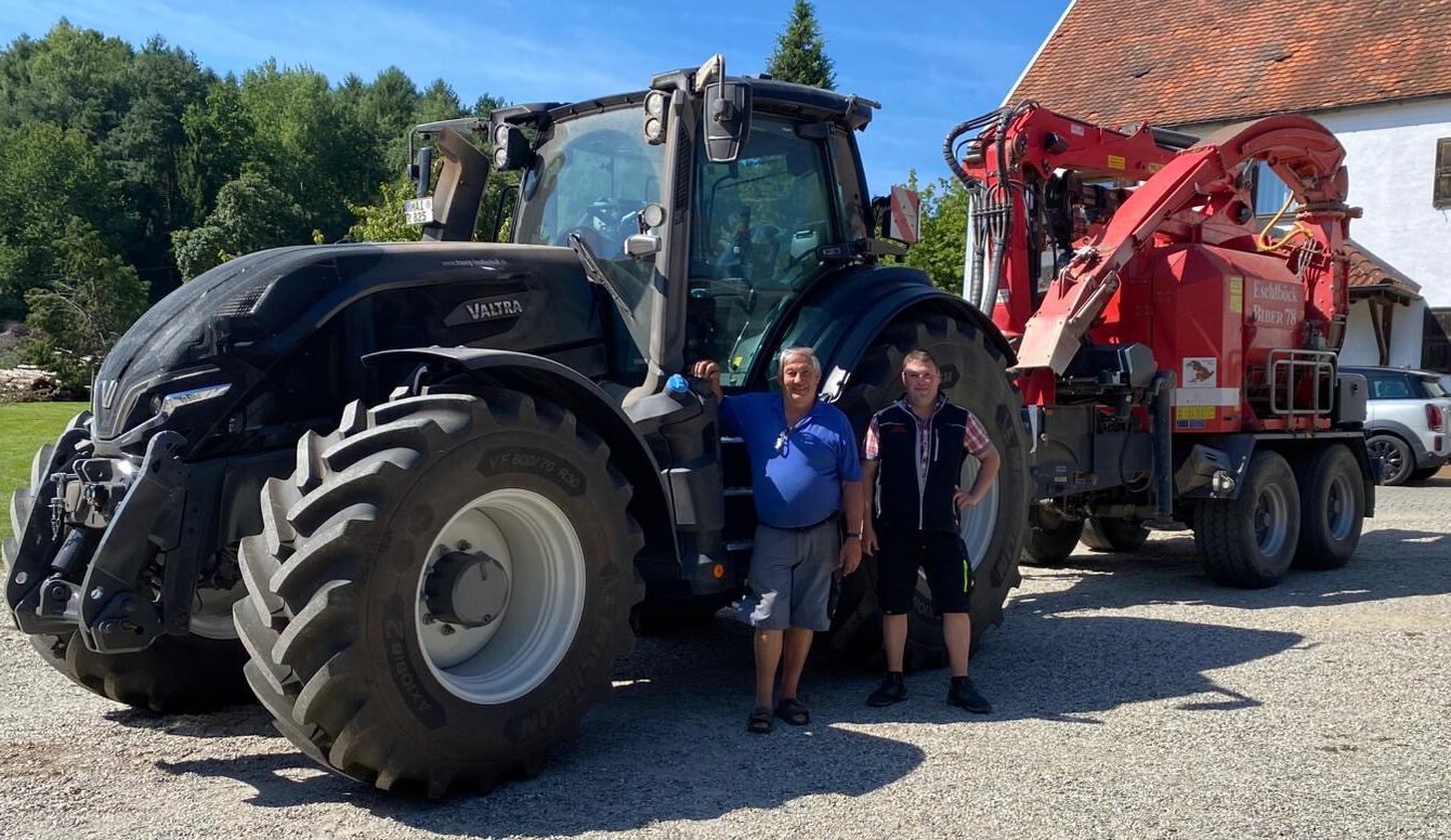 Übergabe-Foto eines Valtras Q305. Zu sehen sind unser Kunde Raith Georg & unser Verkäufer Martin vor dem Valtra-Schlepper.